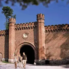 Spacer po historycznej twierdzy Boyen w Giżycku. Trzy osoby idą w stronę bramy.