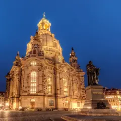 Imponujący kościół Marii Panny w Dreźnie nocą, z pomnikiem Marcina Lutra na pierwszym planie.
