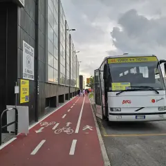 Autobus na lotnisku Treviso z napisem "Venice <-> Treviso". Czerwona ścieżka rowerowa i piesza obok budynku.