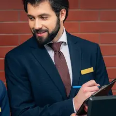 Recepcjonistka odbiera telefon, a recepcjonista notuje. Dyskretnie pytają, czy w hotelu obowiązuje cisza nocna.