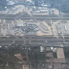 Widok z lotu ptaka na port lotniczy Londyn Heathrow z licznymi samolotami na płycie lotniska i pasami startowymi.