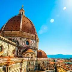 Majestatyczna katedra Santa Maria del Fiore we Florencji, z jej charakterystyczną kopułą, góruje nad miastem w słoneczny dzień.