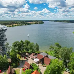 Wieża widokowa nad jeziorem, idealne miejsce, by zobaczyć, co warto zobaczyć na Kaszubach. Żaglówka na wodzie, lasy i chmury.