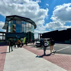 Ludzie z bagażami idą do nowoczesnego terminalu na lotnisku Bruksela Charleroi.