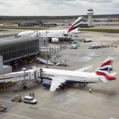 Port lotniczy Londyn Gatwick: samoloty British Airways i Emirates przy rękawach, w tle wieża kontroli lotów.