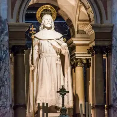 Kamienna postać króla z berłem i jabłkiem, ozdobiona złotym nimbem, stoi w monumentalnym wnętrzu bazyliki św. Stefana w Budapeszcie.