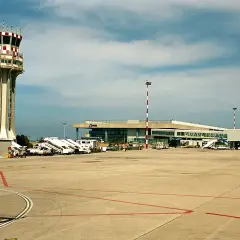 Wieża kontroli lotów i terminal pasażerski na **port lotniczy Palermo**. Samoloty czekają na pasażerów.