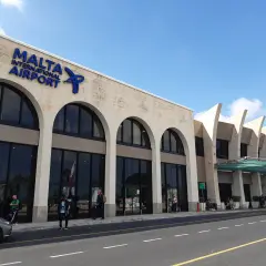Elegancki budynek portu lotniczego Malta z łukowymi oknami i nowoczesnymi elementami architektonicznymi.