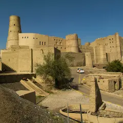 Imponujący fort Bahla w Omanie, z charakterystyczną okrągłą wieżą, góruje nad krajobrazem.