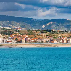 Widok na miasto Reggio di Calabria z pociągiem wzdłuż wybrzeża i błękitnym morzem.