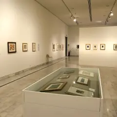 Wystawa w muzeum Picassa w Barcelonie. Obrazy na ścianach i w gablotach, marmurowa posadzka.