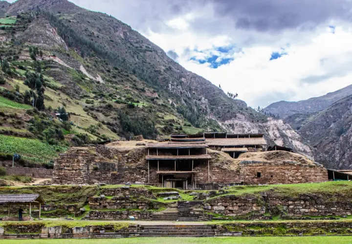 Kamienne ruiny Chavin de Huantar w Peru, otoczone zielonymi zboczami gór.