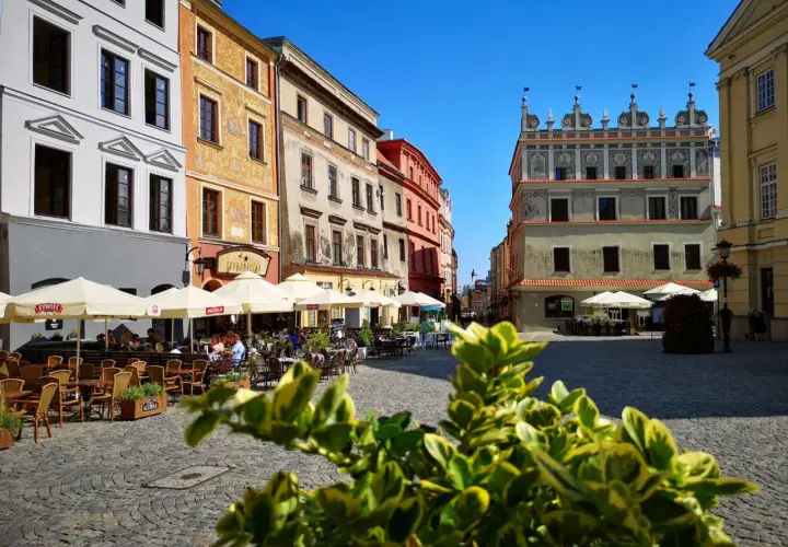 Tętniący życiem rynek w Lublinie. Kolorowe kamienice, kawiarniane ogródki i zabytkowa architektura tworzą urokliwy klimat.