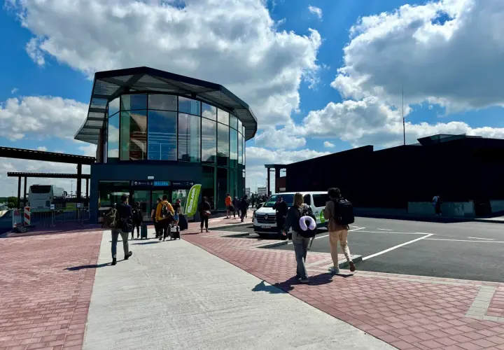 Ludzie z bagażami idą do nowoczesnego terminalu na lotnisku Bruksela Charleroi.