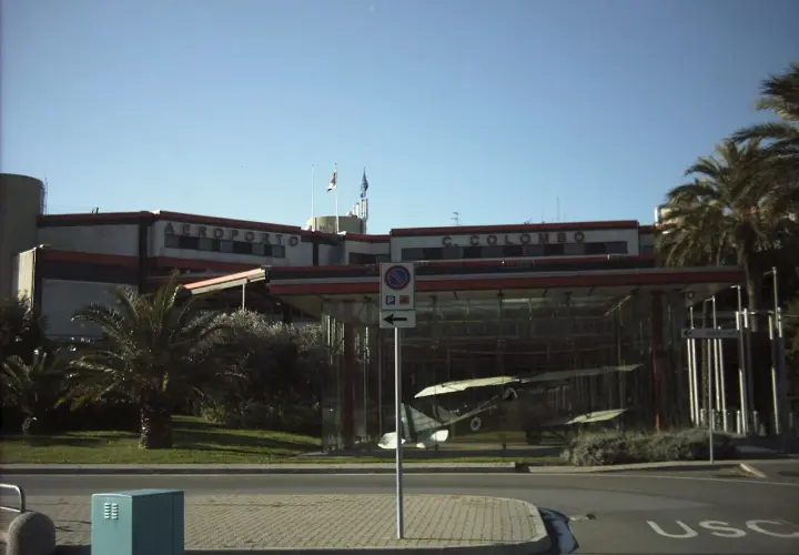 Port lotniczy Genua C. Colombo. W szklanej gablocie stoi zabytkowy samolot.