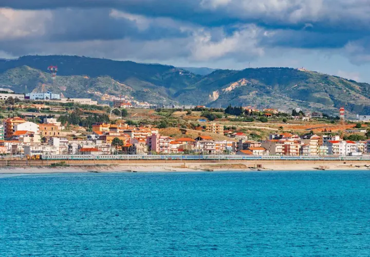 Widok na miasto Reggio di Calabria z pociągiem wzdłuż wybrzeża i błękitnym morzem.