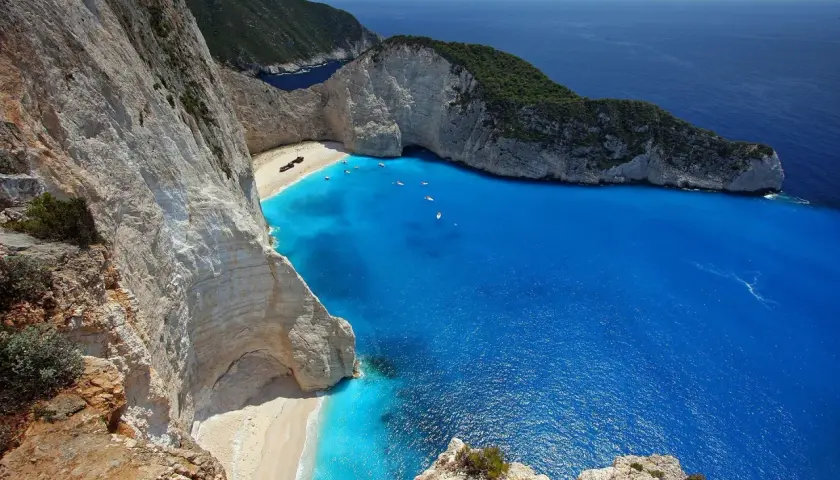 Widok na zatokę wraku Zakynthos z klifu. Turkusowa woda, biała plaża i wrak statku.