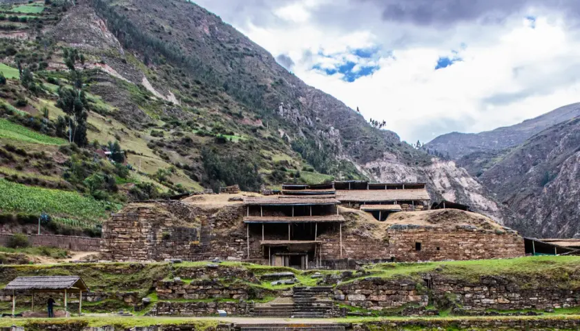 Kamienne ruiny Chavin de Huantar w Peru, otoczone zielonymi zboczami gór.