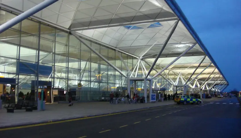 Nowoczesny terminal portu lotniczego Londyn Stansted STN z charakterystycznym dachem i szklanymi fasadami.
