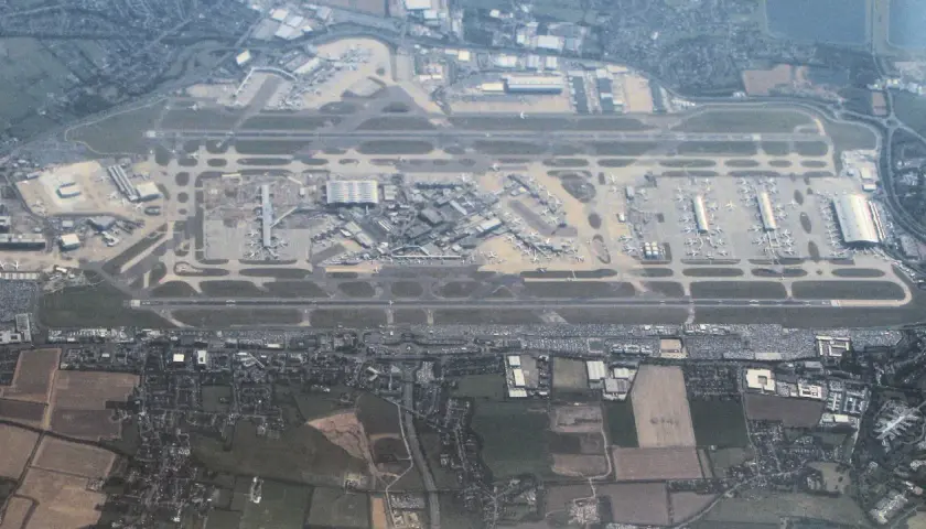 Widok z lotu ptaka na port lotniczy Londyn Heathrow z licznymi samolotami na płycie lotniska i pasami startowymi.