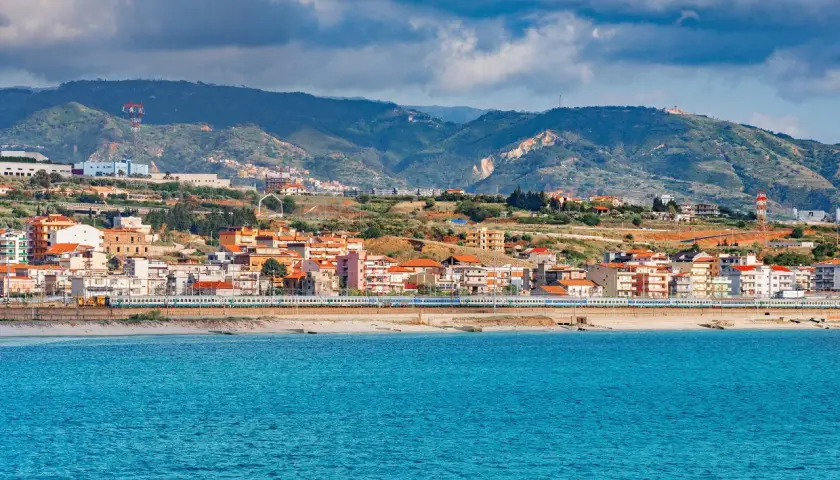 Widok na miasto Reggio di Calabria z pociągiem wzdłuż wybrzeża i błękitnym morzem.
