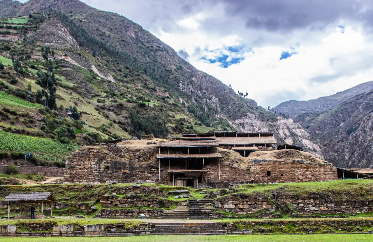 Kamienne ruiny Chavin de Huantar w Peru, otoczone zielonymi zboczami gór.