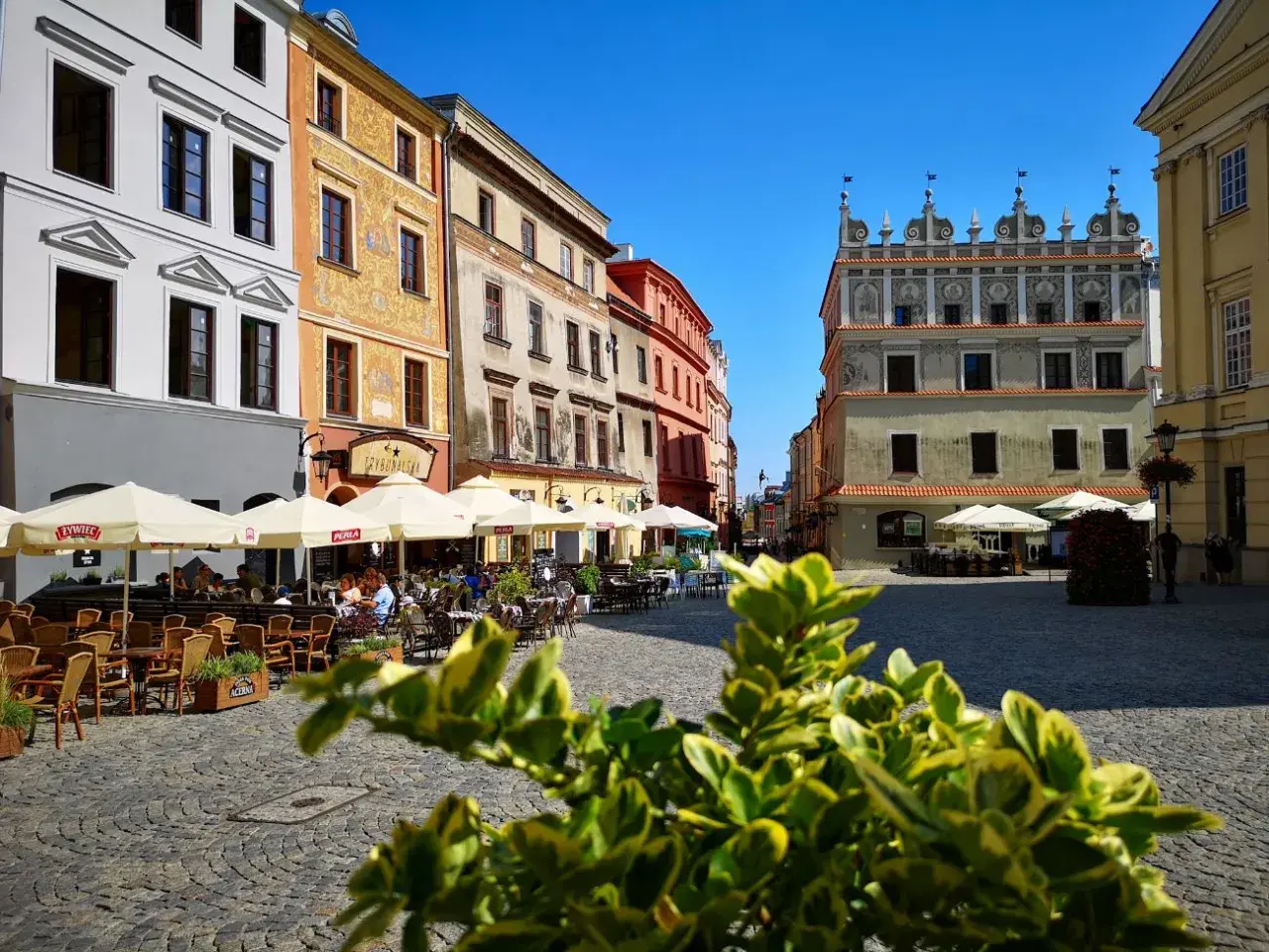 Tętniący życiem rynek w Lublinie. Kolorowe kamienice, kawiarniane ogródki i zabytkowa architektura tworzą urokliwy klimat.