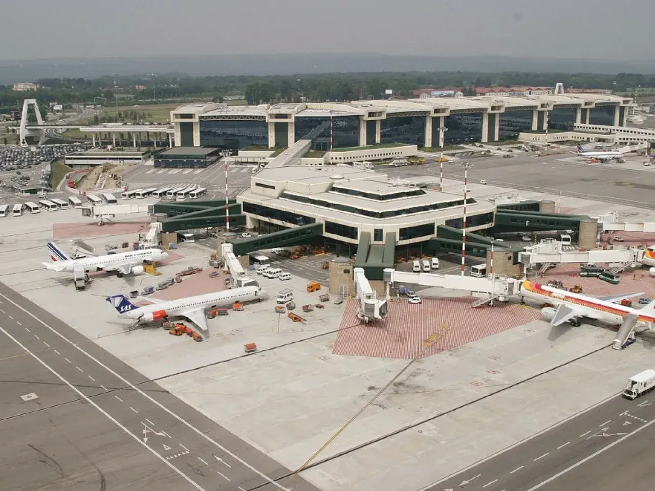 Port lotniczy Mediolan Malpensa tętni życiem. Samoloty Air France i SAS czekają na pasażerów, a nowoczesne terminale obsługują ruch.