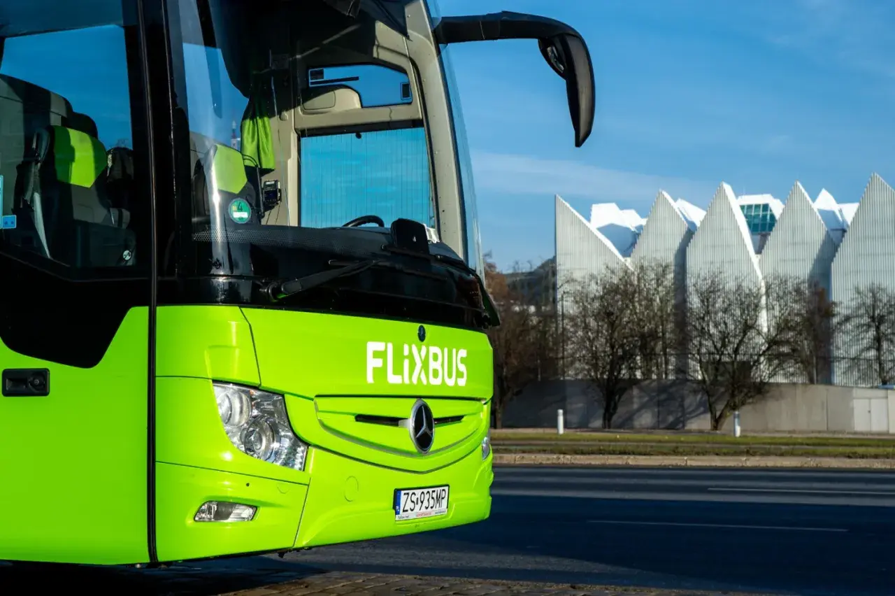 Zielony autokar FlixBus na tle nowoczesnego budynku. Tu zatrzymuje się flixbus w Warszawie.