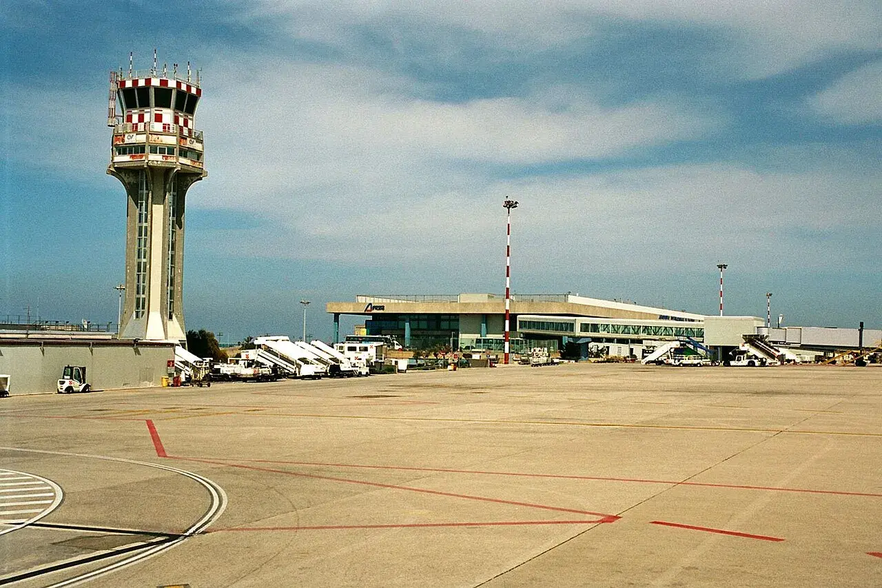 Wieża kontroli lotów i terminal pasażerski na **port lotniczy Palermo**. Samoloty czekają na pasażerów.