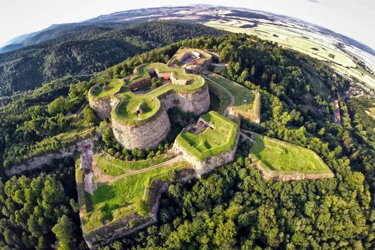 Imponująca twierdza na wzgórzu, jedna z głównych kotlina kłodzka atrakcje, otoczona bujną zielenią.