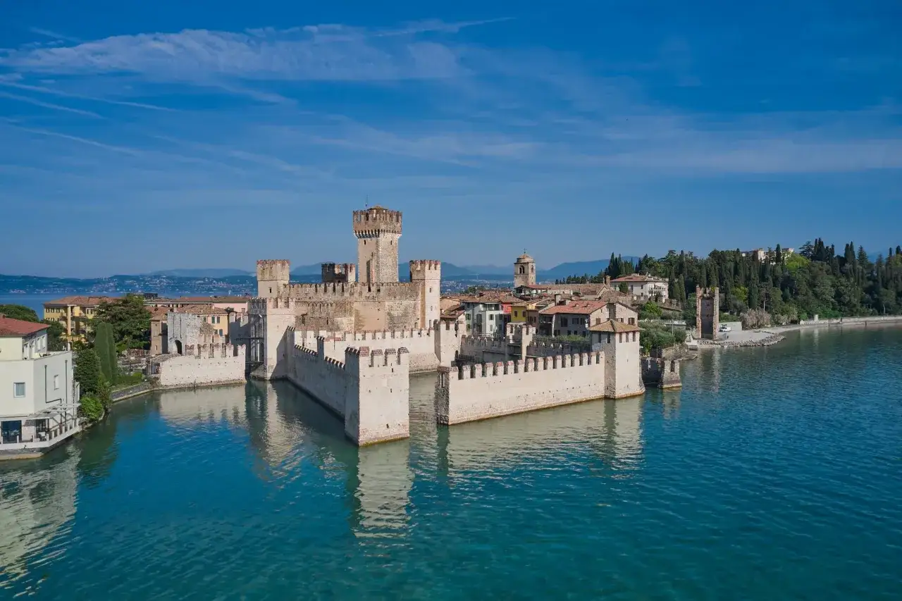 Sirmione Castello Scaligero, majestatyczny zamek otoczony wodą, dumnie wznosi się nad jeziorem.
