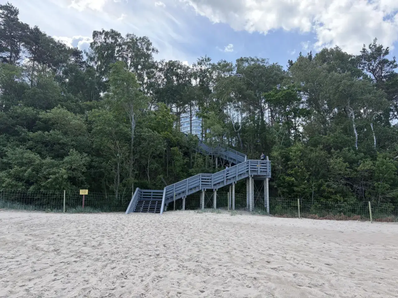 Schody na plaży w Pobierowie prowadzą do lasu, gdzie widać budynek hotelu Gołębiewski. Kiedy otwarcie?