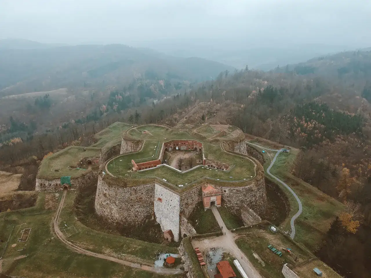 Twierdza w Kotlinie Kłodzkiej, imponująca forteca na tle mglistych wzgórz, to jedna z głównych atrakcji regionu.