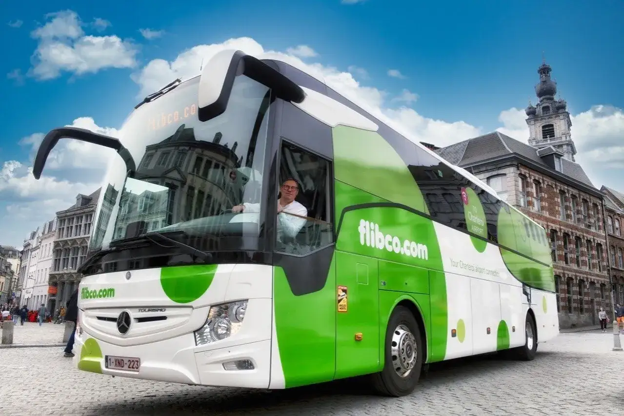 Autobus Flibco.com, Twoje połączenie z lotniskiem Bruksela Charleroi, jedzie brukowaną ulicą.