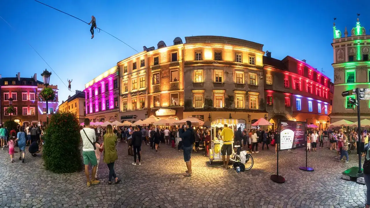Tłum ludzi na lubelskim Rynku, gdzie można zobaczyć akrobatów na linie. Idealne miejsce, by sprawdzić, co zwiedzić w Lublinie!