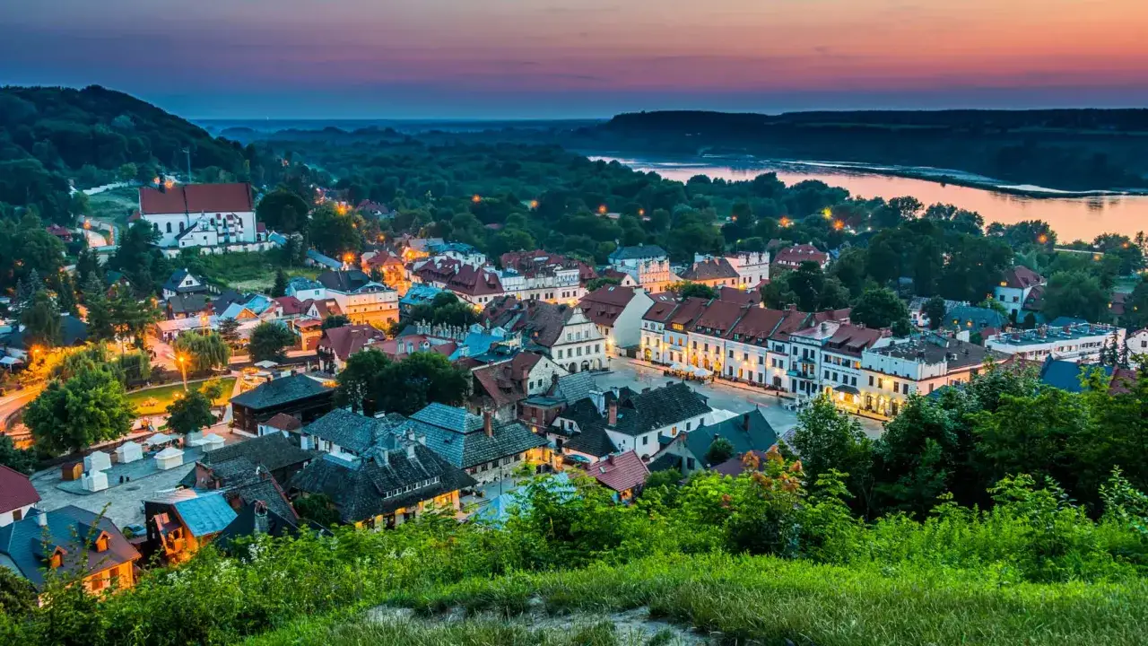 Zachód słońca nad Kazimierzem Dolnym. Widok na rynek, kościół i Wisłę. Kazimierz Dolny atrakcje zachwycają o każdej porze.