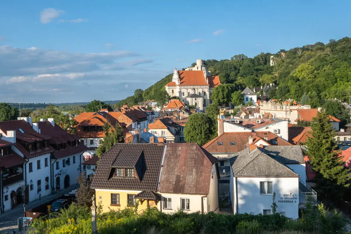 Widok na urokliwe stare miasto w Kazimierzu Dolnym z charakterystycznymi kamieniczkami i kościołem na wzgórzu.