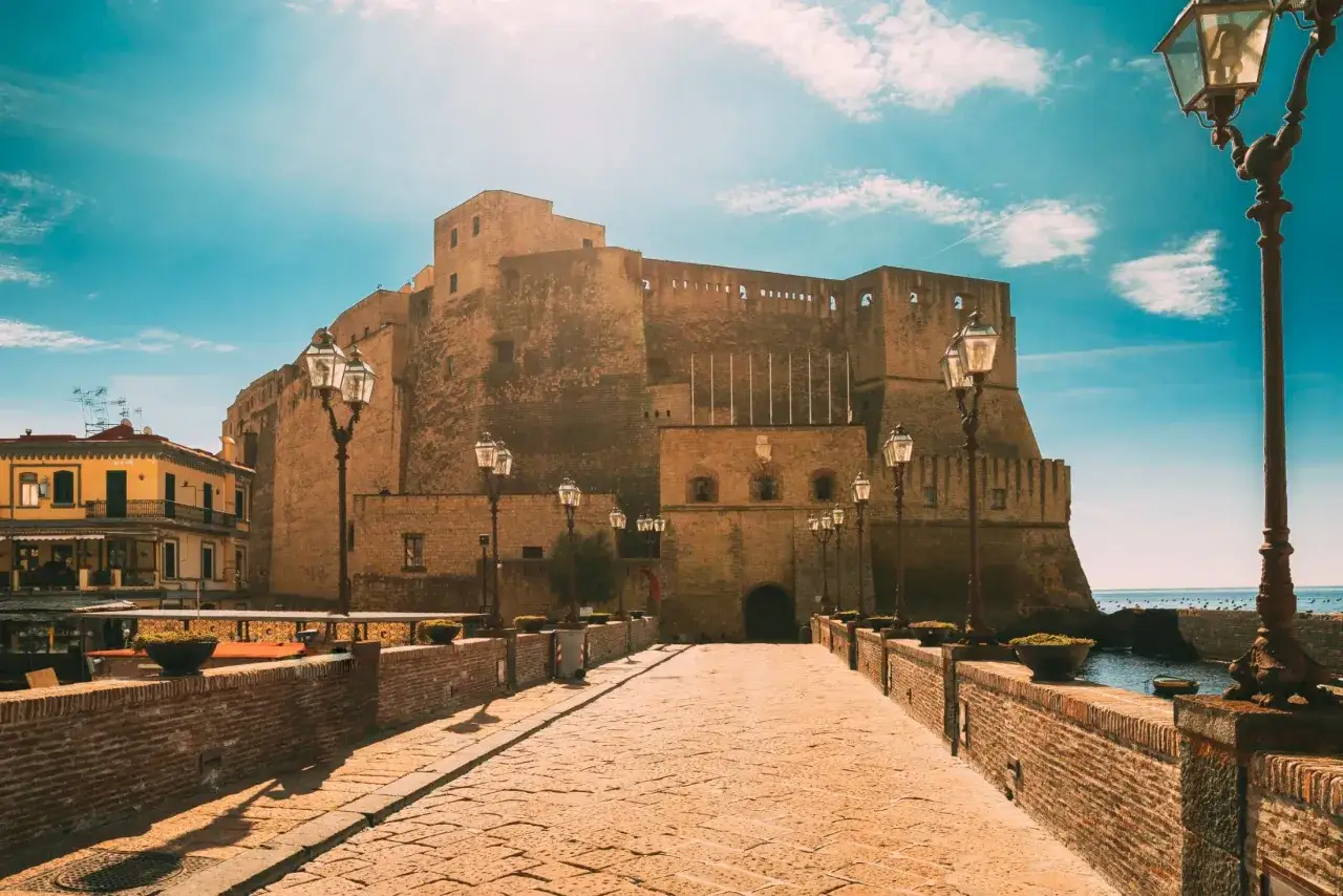 Castel dell'Ovo w Neapolu, idealne miejsce, by zobaczyć, co oferuje to miasto. Kamienna ścieżka prowadzi do imponującej fortecy nad wodą.