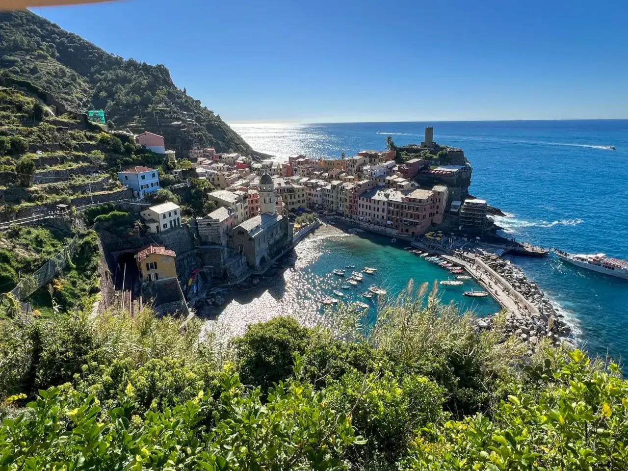 Kolorowe domy Vernazzy, perły Cinque Terre w prowincji La Spezia we Włoszech, lśnią w słońcu nad turkusową zatoką.