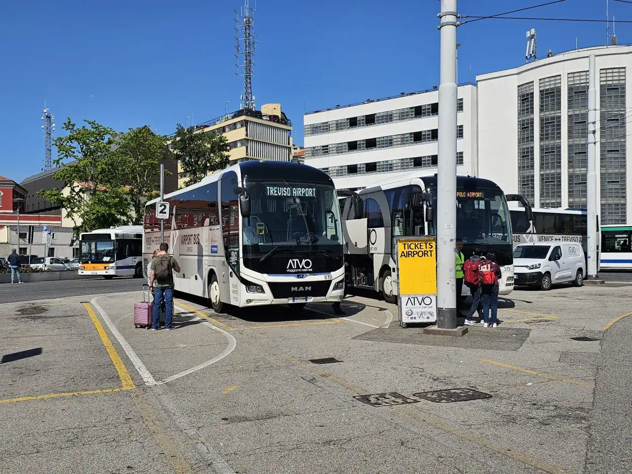 Autobusy ATVO na lotnisku Treviso. Ludzie z walizkami czekają na transport.