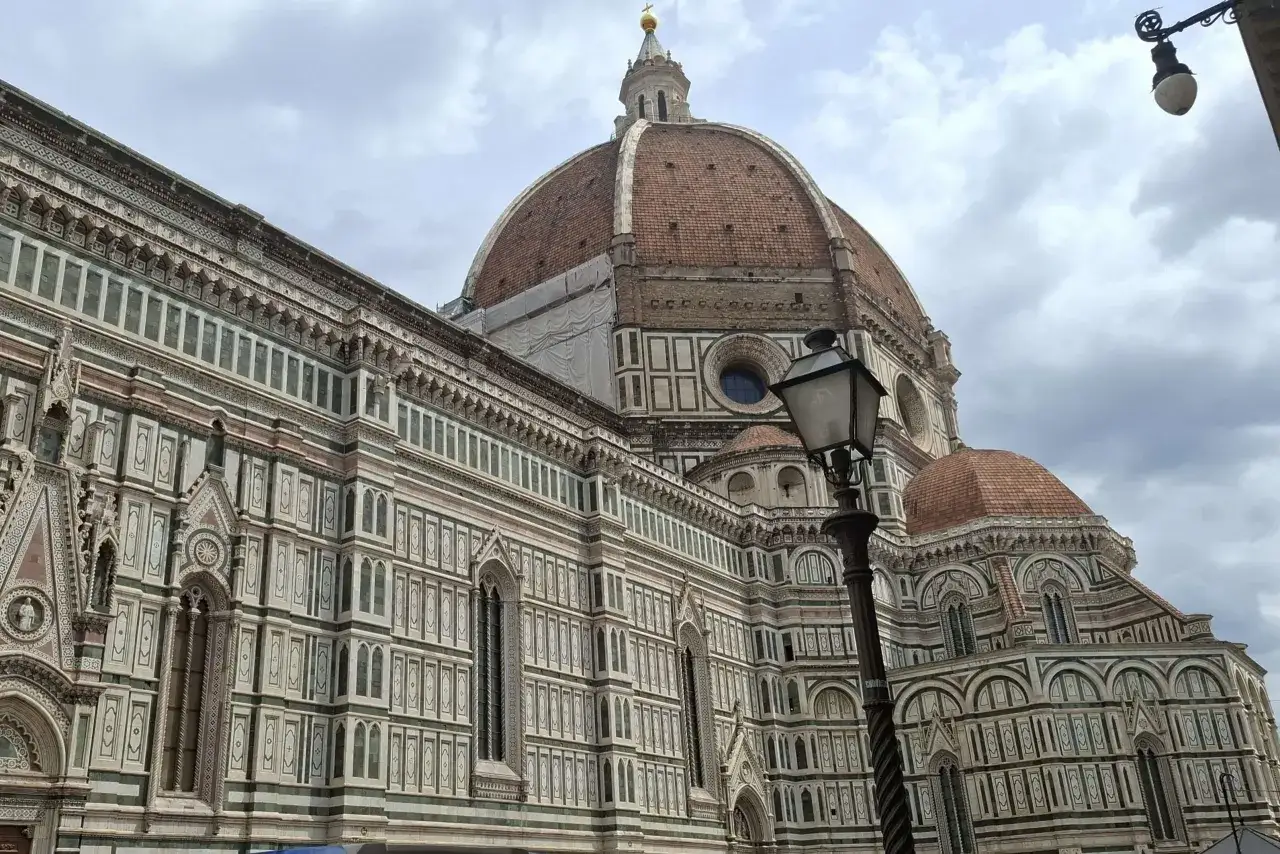 Majestatyczna katedra Santa Maria del Fiore we Florencji z charakterystyczną kopułą i bogato zdobioną fasadą.