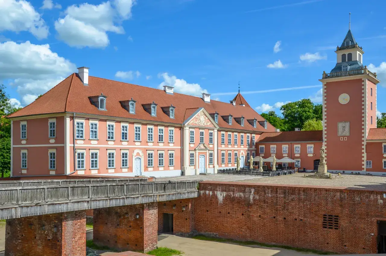 Zamek biskupów warmińskich w Lidzbarku Warmińskim, wspaniałe atrakcje turystyczne. Majestatyczna budowla z czerwoną dachówką i wieżą zegarową.