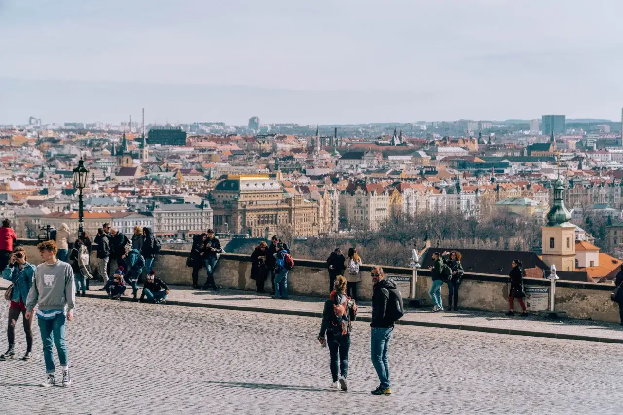 Spacerem po brukowanym placu z widokiem na panoramę miasta i zamek na Hradczanach.