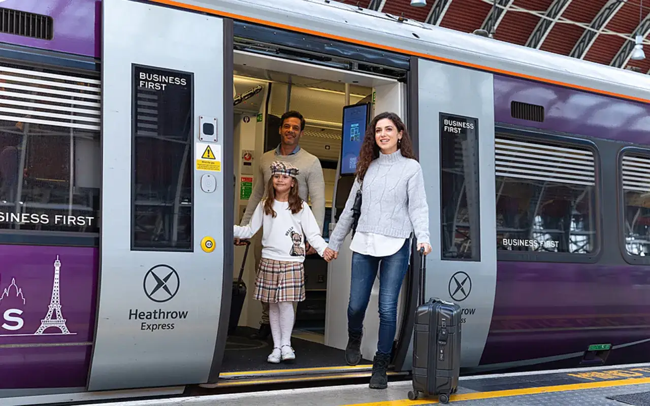 Rodzina wsiada do pociągu Heathrow Express. Podróż na lotnisko Londyn Heathrow z klasą Business First.
