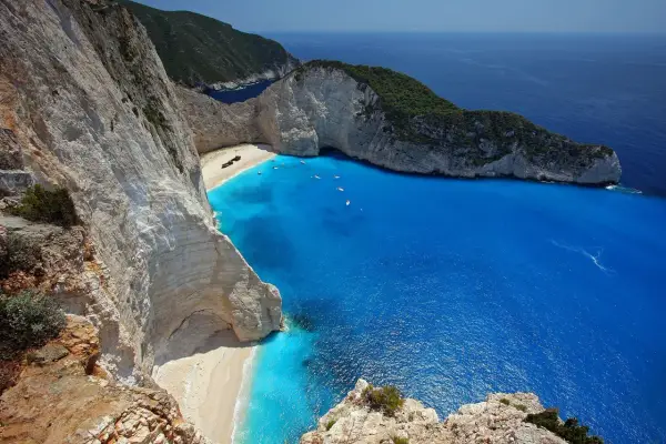 Widok na zatokę wraku Zakynthos z klifu. Turkusowa woda, biała plaża i wrak statku.