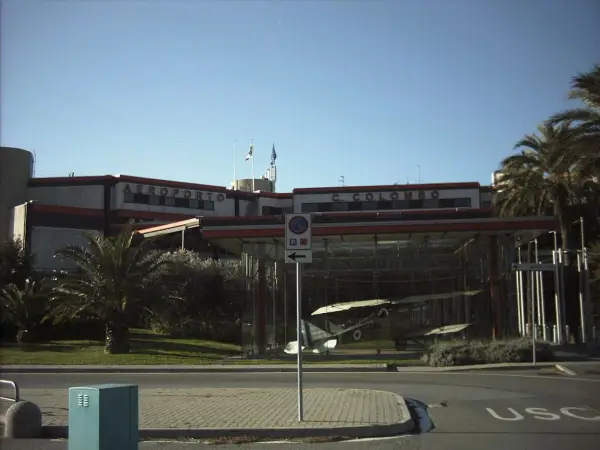 Port lotniczy Genua C. Colombo. W szklanej gablocie stoi zabytkowy samolot.